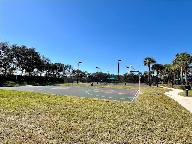 view of sport court with a yard