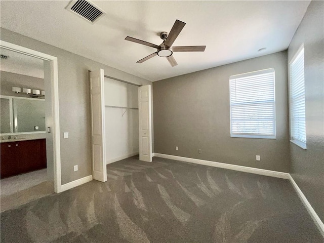 unfurnished bedroom featuring dark colored carpet and ceiling fan