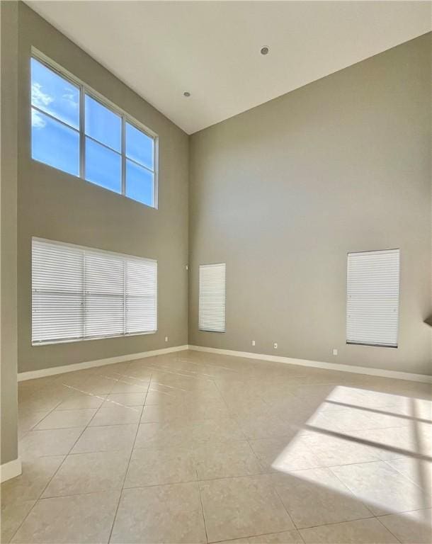 tiled empty room with a towering ceiling