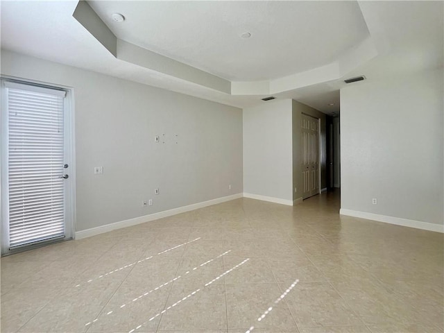 spare room with a tray ceiling