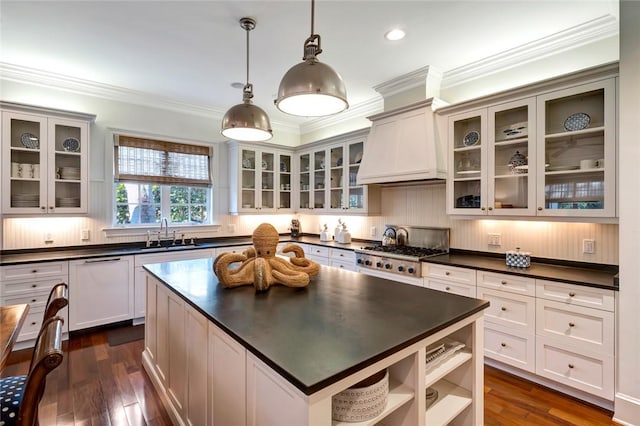 kitchen featuring sink, a center island, custom exhaust hood, stainless steel gas stovetop, and pendant lighting