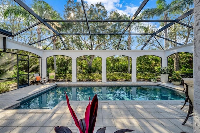 view of pool with a patio area and glass enclosure