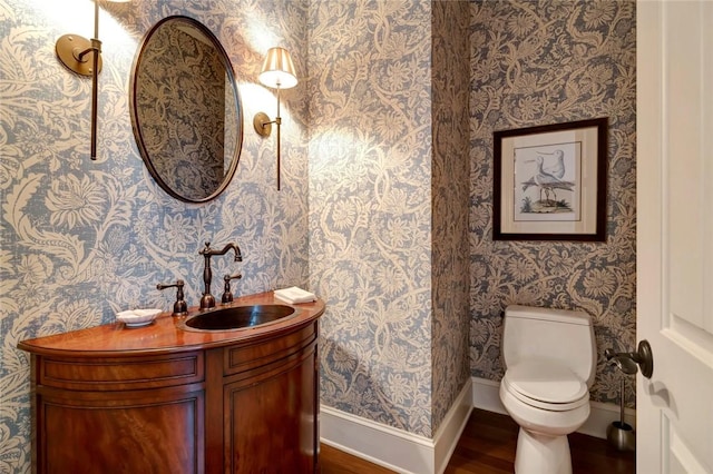 bathroom featuring toilet, wood-type flooring, and vanity