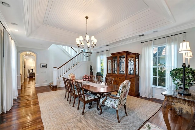 dining room featuring an inviting chandelier, a tray ceiling, crown molding, and dark hardwood / wood-style floors