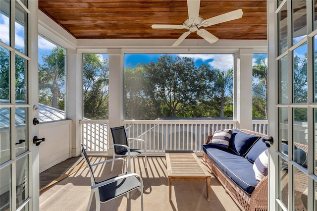 sunroom with ceiling fan and wooden ceiling