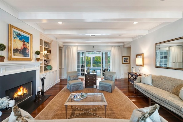 living room with beam ceiling, dark hardwood / wood-style floors, and built in shelves