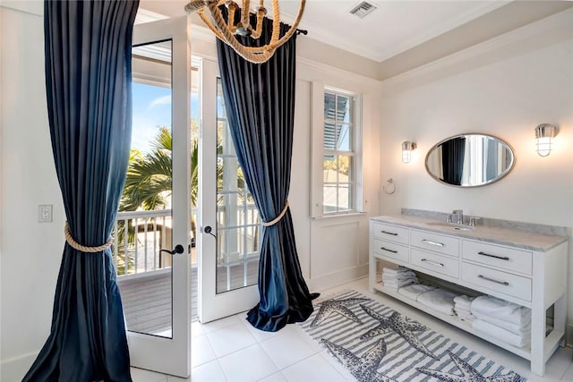 bathroom featuring plenty of natural light, tile patterned flooring, crown molding, and vanity