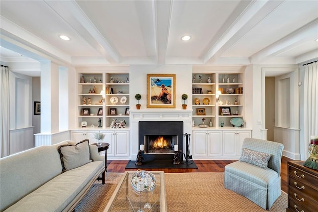 living room featuring dark hardwood / wood-style flooring, ornamental molding, built in shelves, and beam ceiling