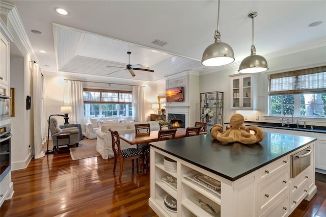 kitchen with white cabinets, pendant lighting, ornamental molding, and ceiling fan