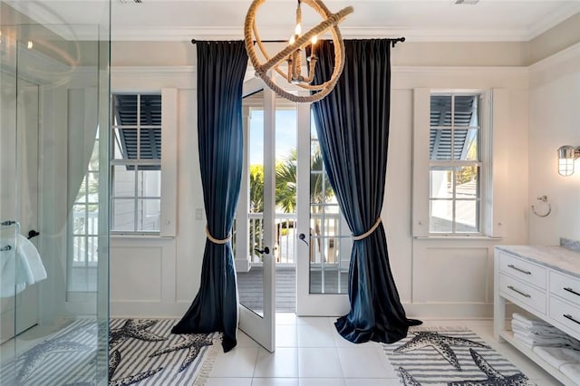 doorway to outside with crown molding, an inviting chandelier, french doors, and light tile patterned floors