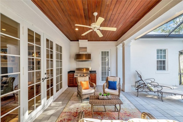 sunroom / solarium with ceiling fan, wood ceiling, french doors, and ornate columns