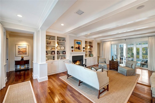 living room featuring ornamental molding, french doors, hardwood / wood-style flooring, beam ceiling, and built in features