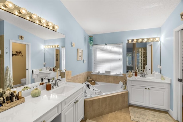 223 River Walk Unit 12, Hutchinson Island, FL 34949 - full bathroom featuring a bath, two vanities, and tile patterned flooring