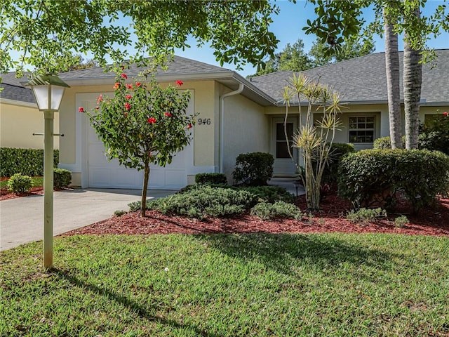 ranch-style home featuring concrete driveway, a front yard, roof with shingles, stucco siding, and a garage