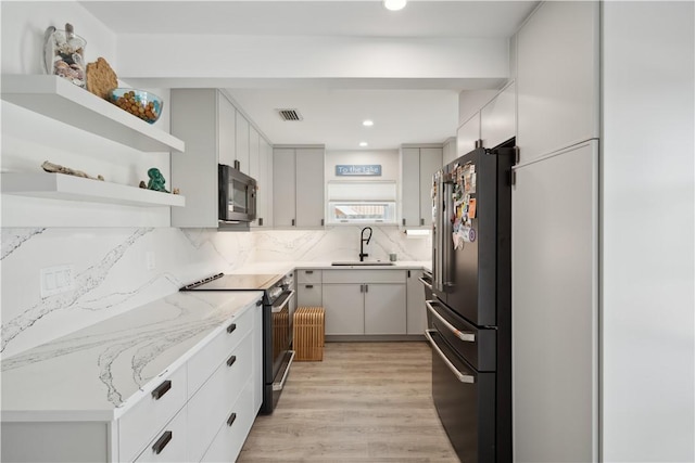 1933 Robalo Dr, Vero Beach, FL 32960 - kitchen featuring freestanding refrigerator, stainless steel electric range oven, open shelves, black microwave, and backsplash