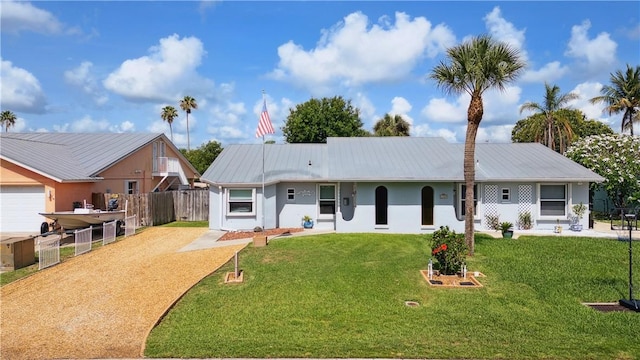 1933 Robalo Dr, Vero Beach, FL 32960 - view of front of home featuring stucco siding, a metal roof, and driveway