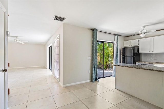 415 E Waverly Pl Unit 1C, Vero Beach, FL 32960 - kitchen with visible vents, a ceiling fan, freestanding refrigerator, and dark stone counters
