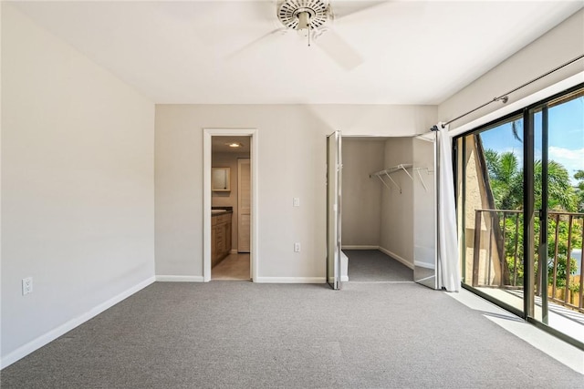 415 E Waverly Pl Unit 1C, Vero Beach, FL 32960 - unfurnished bedroom with ceiling fan, baseboards, ensuite bath, access to outside, and carpet flooring