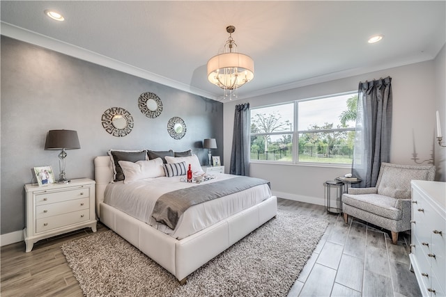 bedroom with a chandelier, wood-type flooring, and crown molding