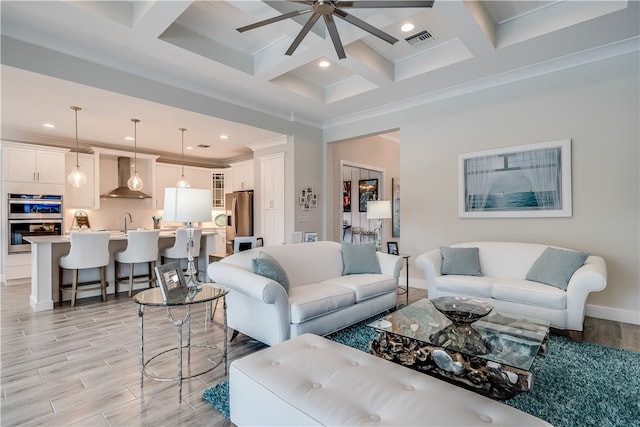 living room with coffered ceiling, sink, crown molding, light hardwood / wood-style flooring, and beamed ceiling