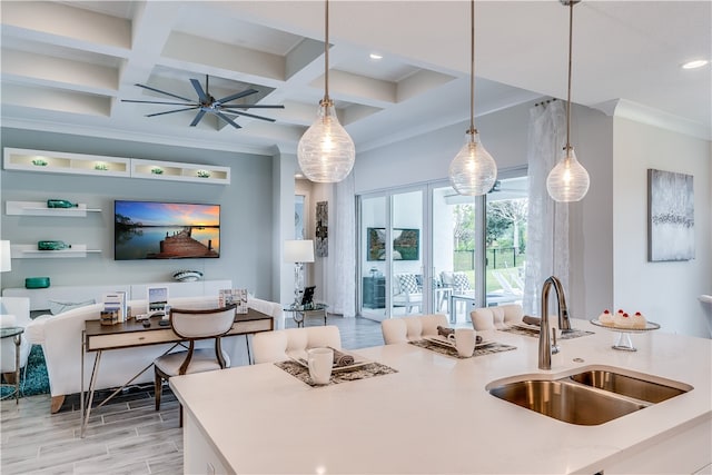 kitchen featuring beam ceiling, sink, hanging light fixtures, and coffered ceiling