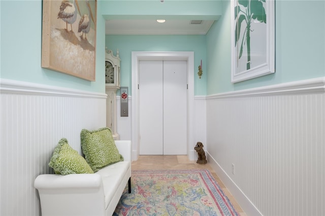 living area with elevator, wainscoting, and visible vents