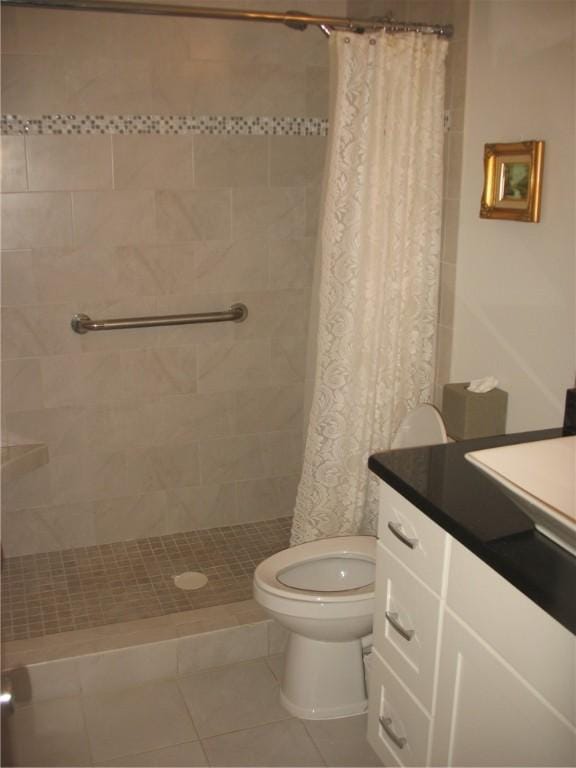 bathroom with walk in shower, tile patterned flooring, vanity, and toilet