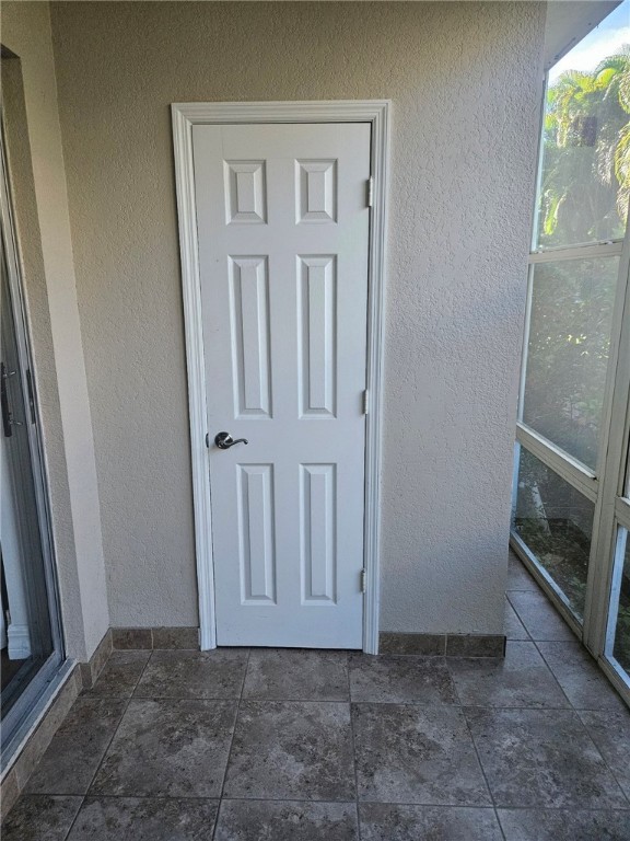 view of exterior entry with a balcony