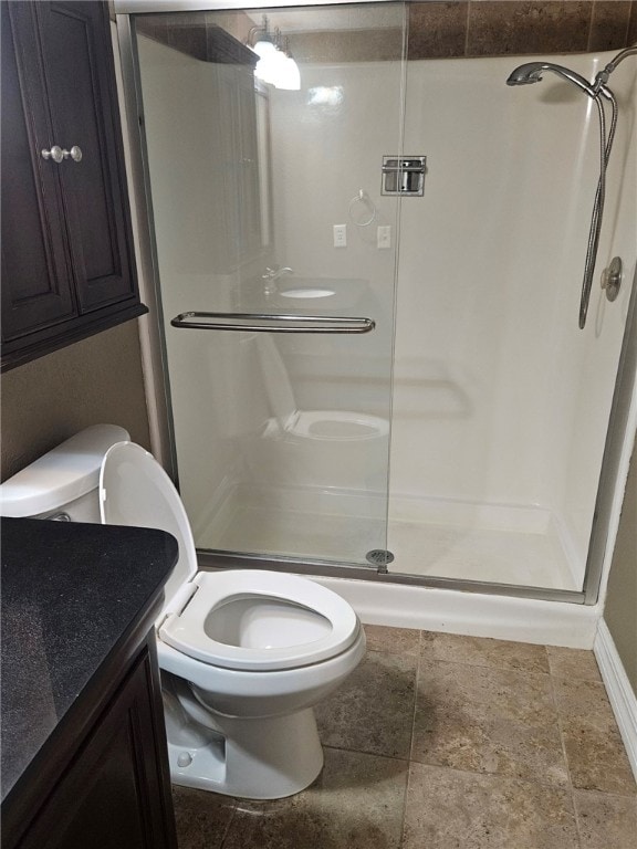 bathroom featuring vanity, toilet, and a shower with door