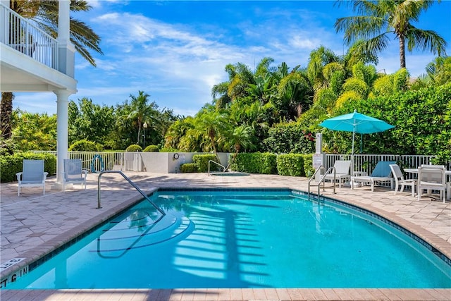 pool featuring fence and a patio area