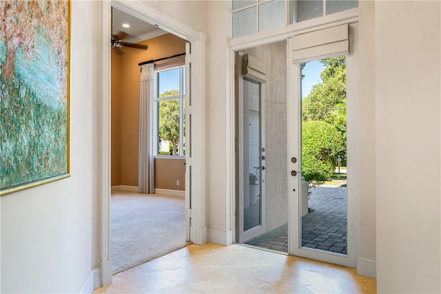 doorway to outside featuring carpet and baseboards