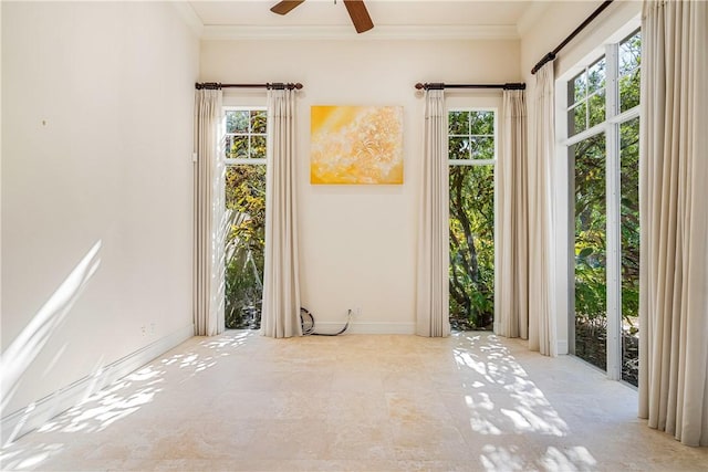 spare room featuring baseboards, a ceiling fan, and ornamental molding