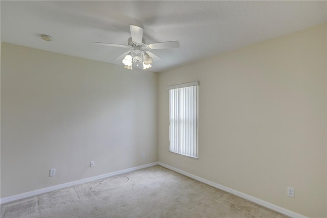 empty room featuring light carpet, baseboards, and ceiling fan