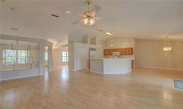 unfurnished living room with light wood-type flooring, baseboards, high vaulted ceiling, and visible vents