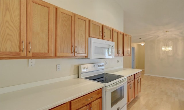kitchen featuring hanging light fixtures, light countertops, a chandelier, and white appliances