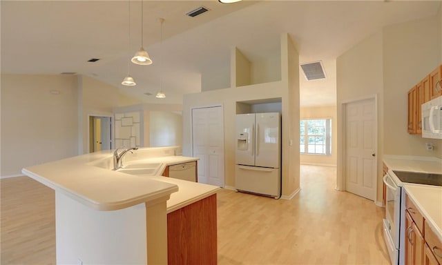 kitchen featuring a spacious island, light wood-style flooring, a sink, and white appliances
