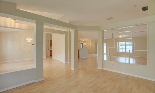 unfurnished room featuring baseboards, light wood finished floors, visible vents, and ceiling fan with notable chandelier