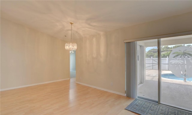 interior space featuring a chandelier, baseboards, and wood finished floors