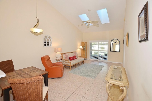 tiled living room with a skylight, ceiling fan, and high vaulted ceiling