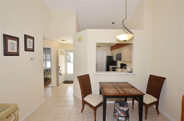 tiled dining room featuring a high ceiling