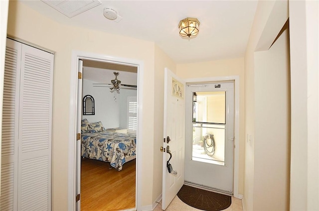 doorway featuring ceiling fan and light wood-type flooring