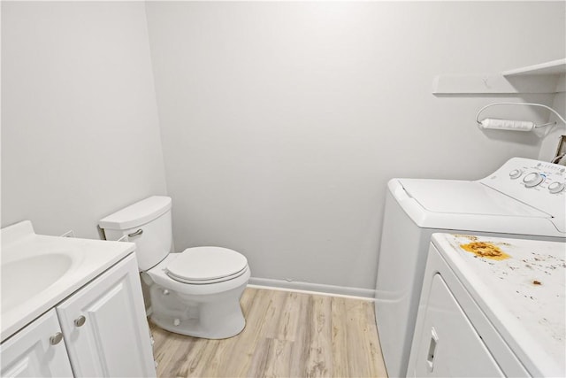 bathroom with vanity, toilet, wood finished floors, and washer and clothes dryer