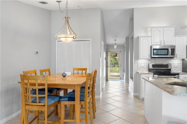 dining room featuring baseboards, visible vents, and light tile patterned floors