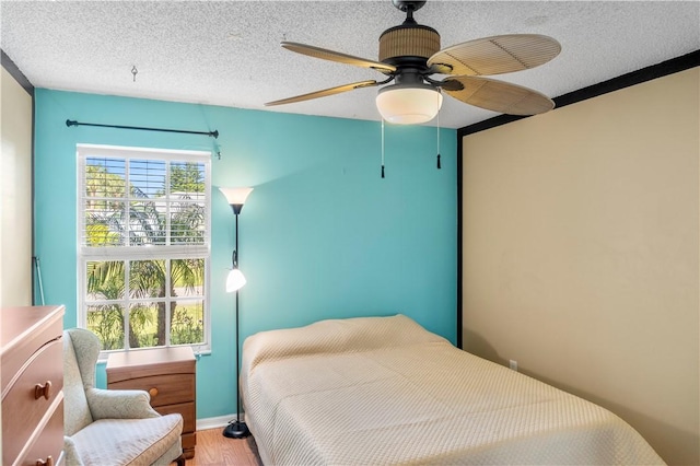 bedroom with multiple windows, ceiling fan, and a textured ceiling