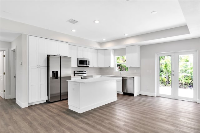 kitchen featuring appliances with stainless steel finishes, dark hardwood / wood-style flooring, white cabinetry, and a healthy amount of sunlight