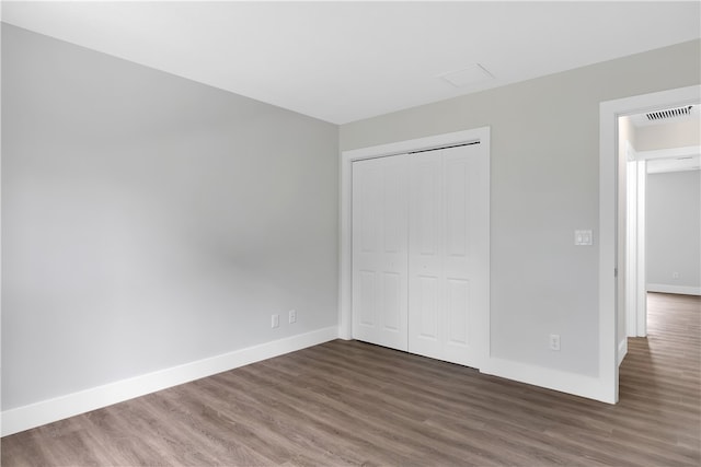 unfurnished bedroom featuring dark hardwood / wood-style flooring and a closet