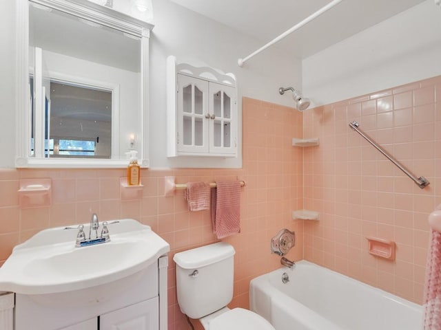 full bathroom with vanity, toilet, tile walls, and tiled shower / bath combo