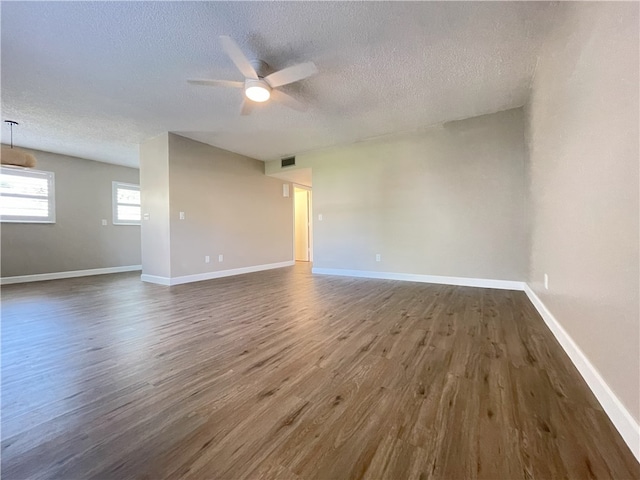 unfurnished room with dark wood-type flooring, a textured ceiling, and ceiling fan