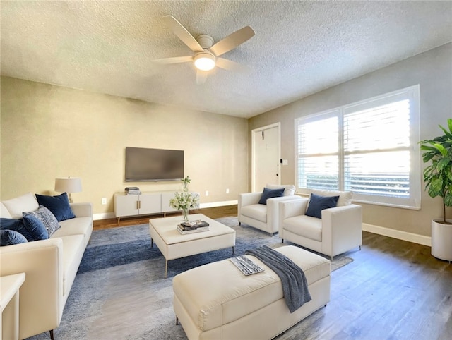 living room featuring dark hardwood / wood-style flooring, a textured ceiling, and ceiling fan