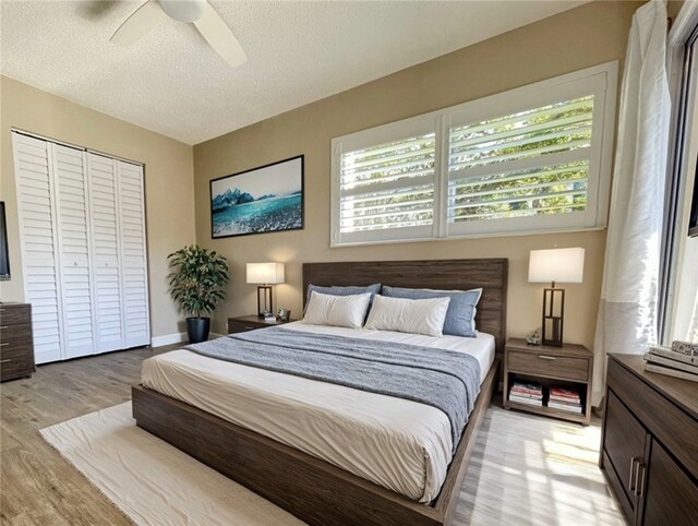 bedroom with ceiling fan, multiple windows, a closet, and a textured ceiling